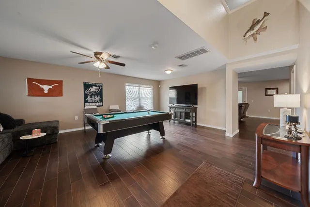 a living room with furniture a wooden floor and potted plants