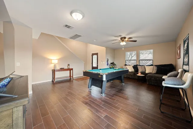 a living room with furniture and a wooden floor