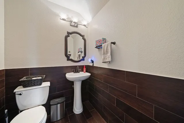 a bathroom with a toilet sink and mirror