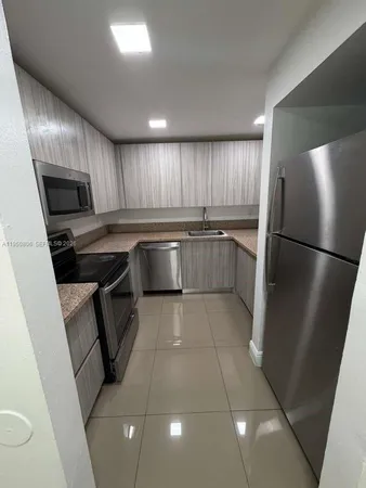 a kitchen with a sink stainless steel appliances a refrigerator and a sink
