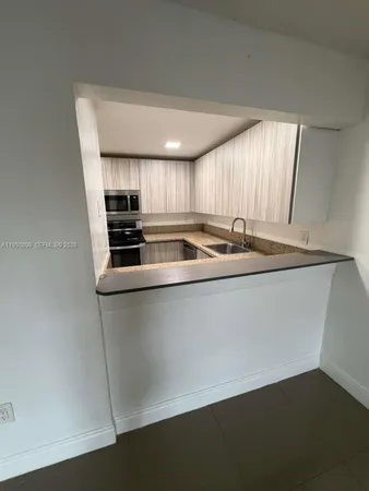 a kitchen with a sink a stove a microwave and wooden floor