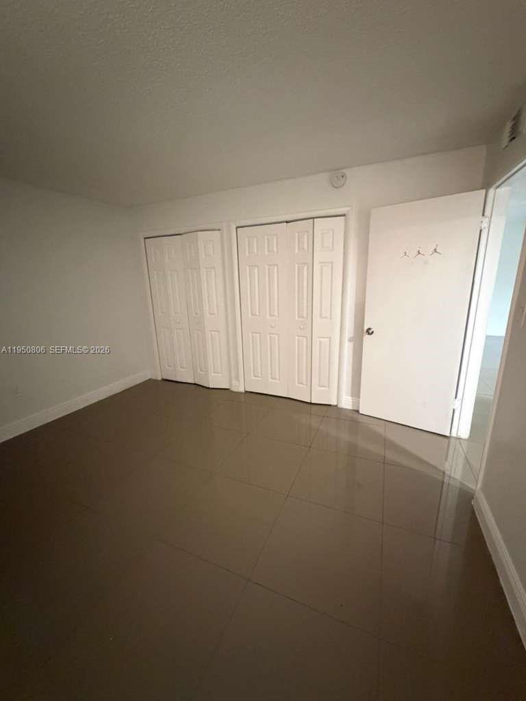 6980 Northwest 186th Street, Unit 3321 Hialeah, FL 33015 - Photo 9 of 10 an empty room with a door