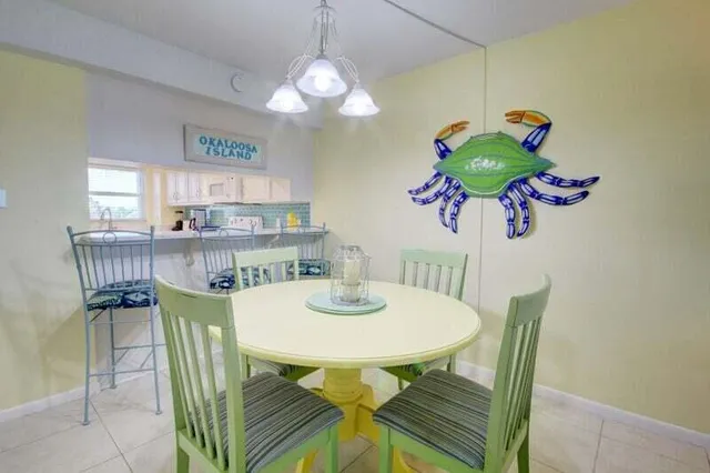 a dining room filled chandelier and kitchen view