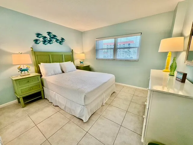 a bedroom with a bed a dresser and a window