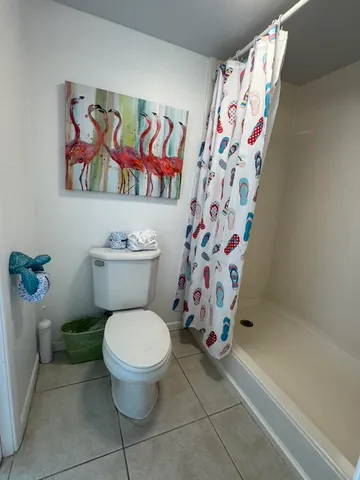 a bathroom with a toilet and a shower curtain