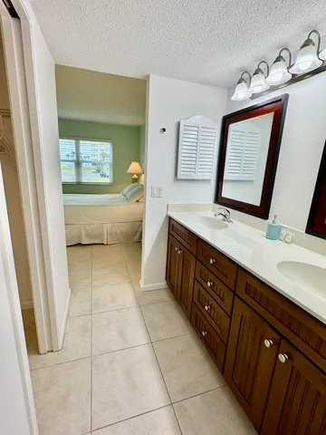 a spacious bathroom with a double vanity sink a mirror and a bathtub