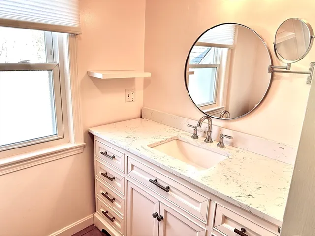 a bathroom with a granite countertop sink and a mirror