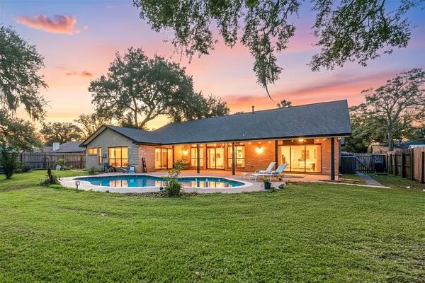 a front view of a house with a big yard and potted plants
