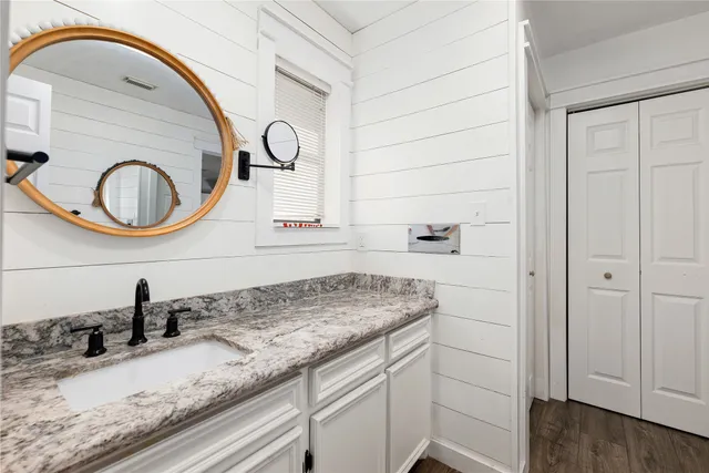 a bathroom with a granite countertop sink and a mirror