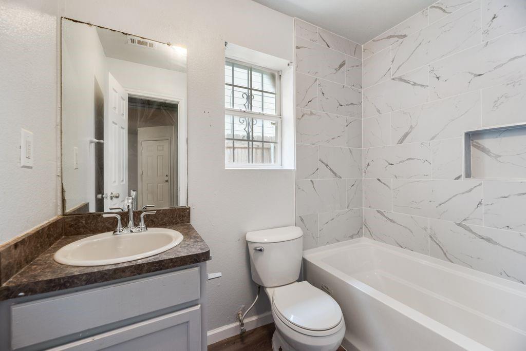 2526 Exeter Avenue Dallas, TX 75216 - Photo 16 of 19 Bathroom featuring a vanity with a laminate countertop, a drop-in sink, and a chrome faucet