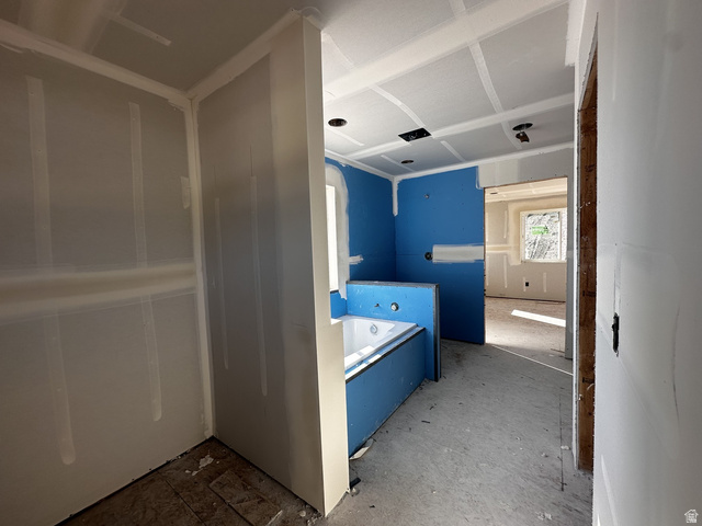 513 East Upper Cyn Road Smithfield, UT 84335 - Photo 13 of 25 Bathroom under construction featuring a built-in soaking tub, blue waterproof wallboard, drywall-finished walls, ceiling with recessed lighting cutouts, and an entryway to another room with a window