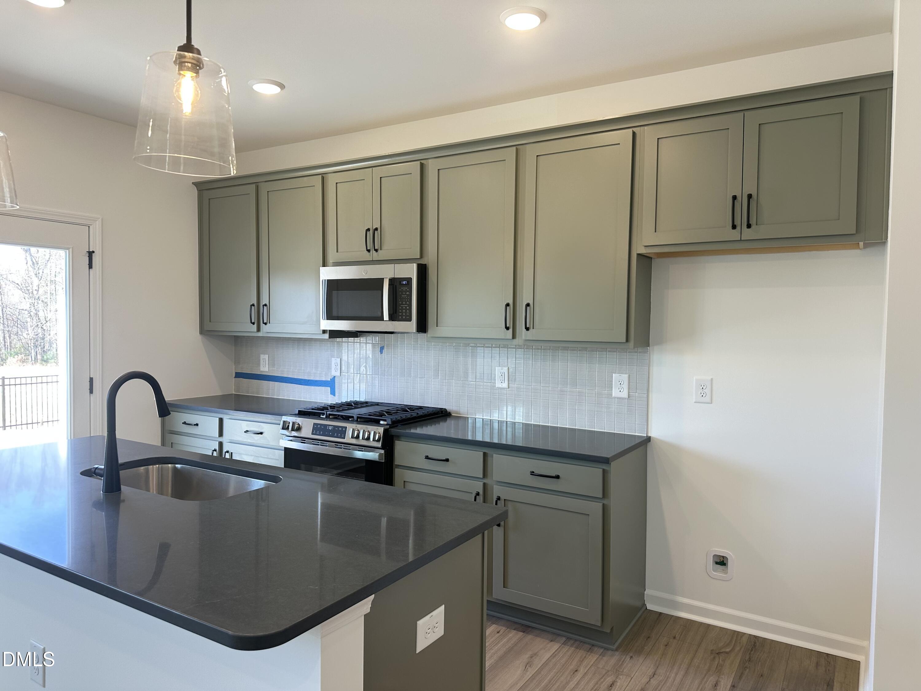 1526 Mirth Court Rolesville, NC 27571 - Photo 11 of 34 a kitchen with kitchen island granite countertop a sink a stove and cabinets