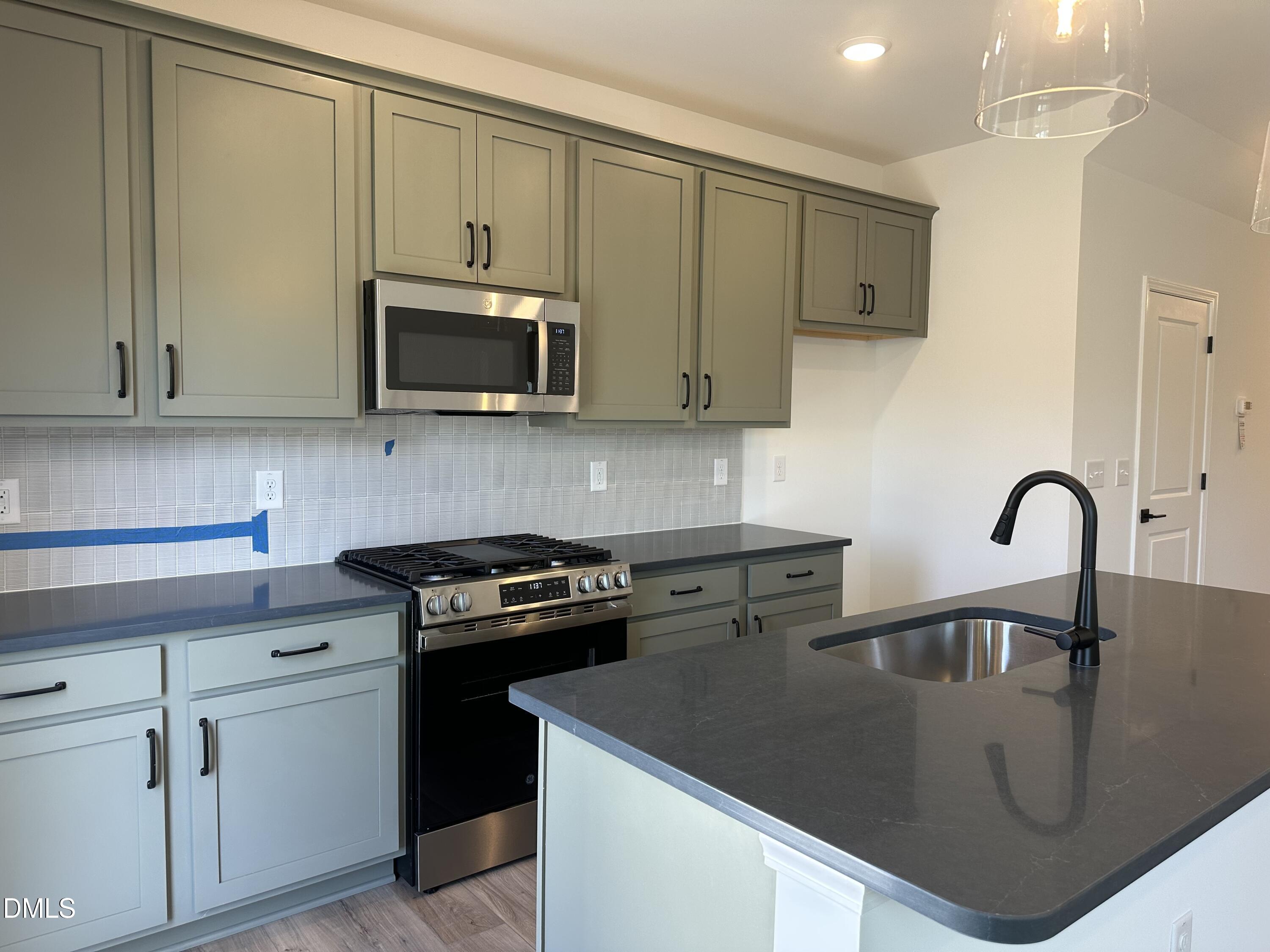 1526 Mirth Court Rolesville, NC 27571 - Photo 12 of 34 a kitchen with stainless steel appliances granite countertop a sink a stove a microwave and cabinets