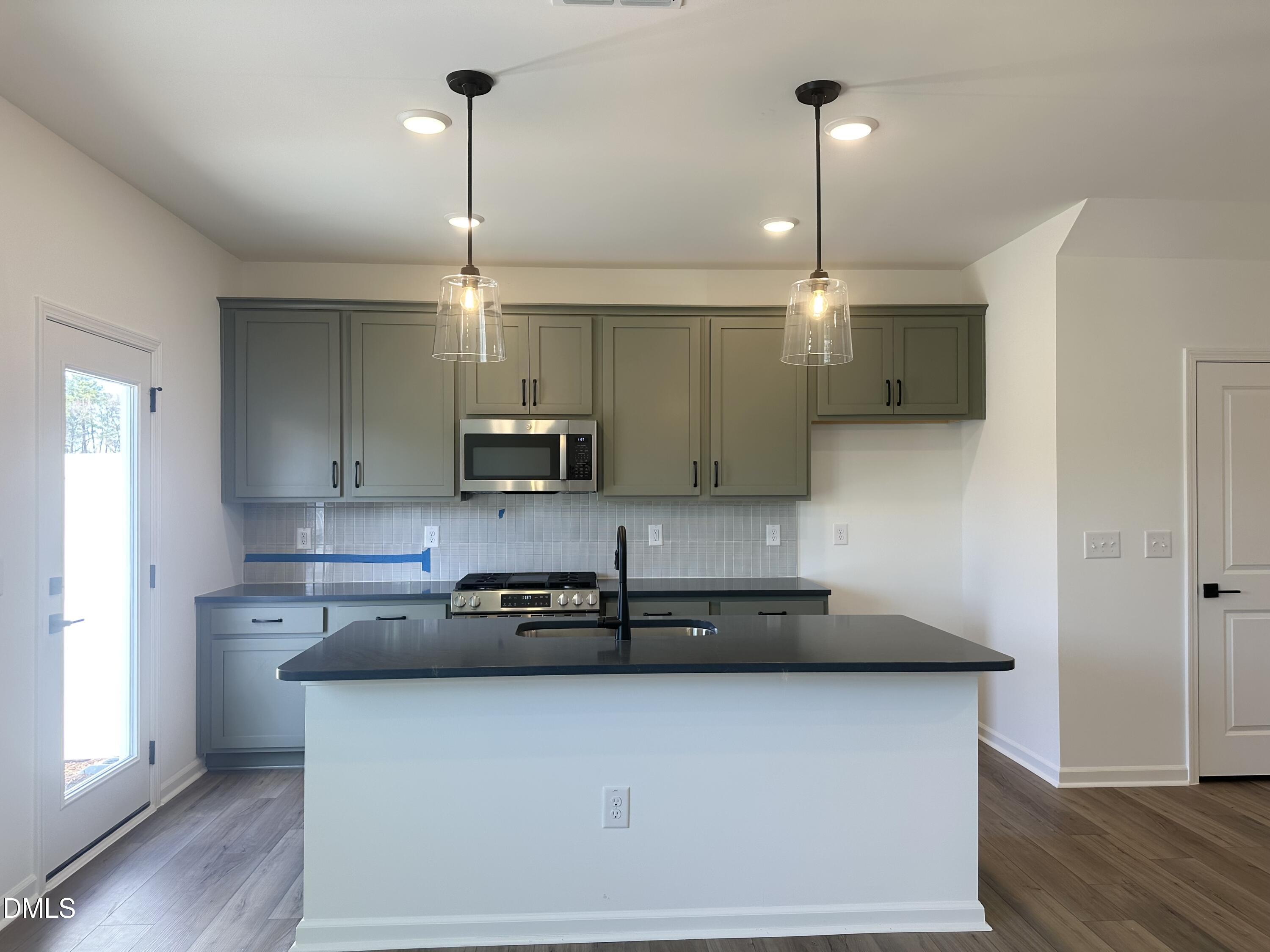 1526 Mirth Court Rolesville, NC 27571 - Photo 10 of 34 a kitchen with kitchen island a counter space a sink and appliances
