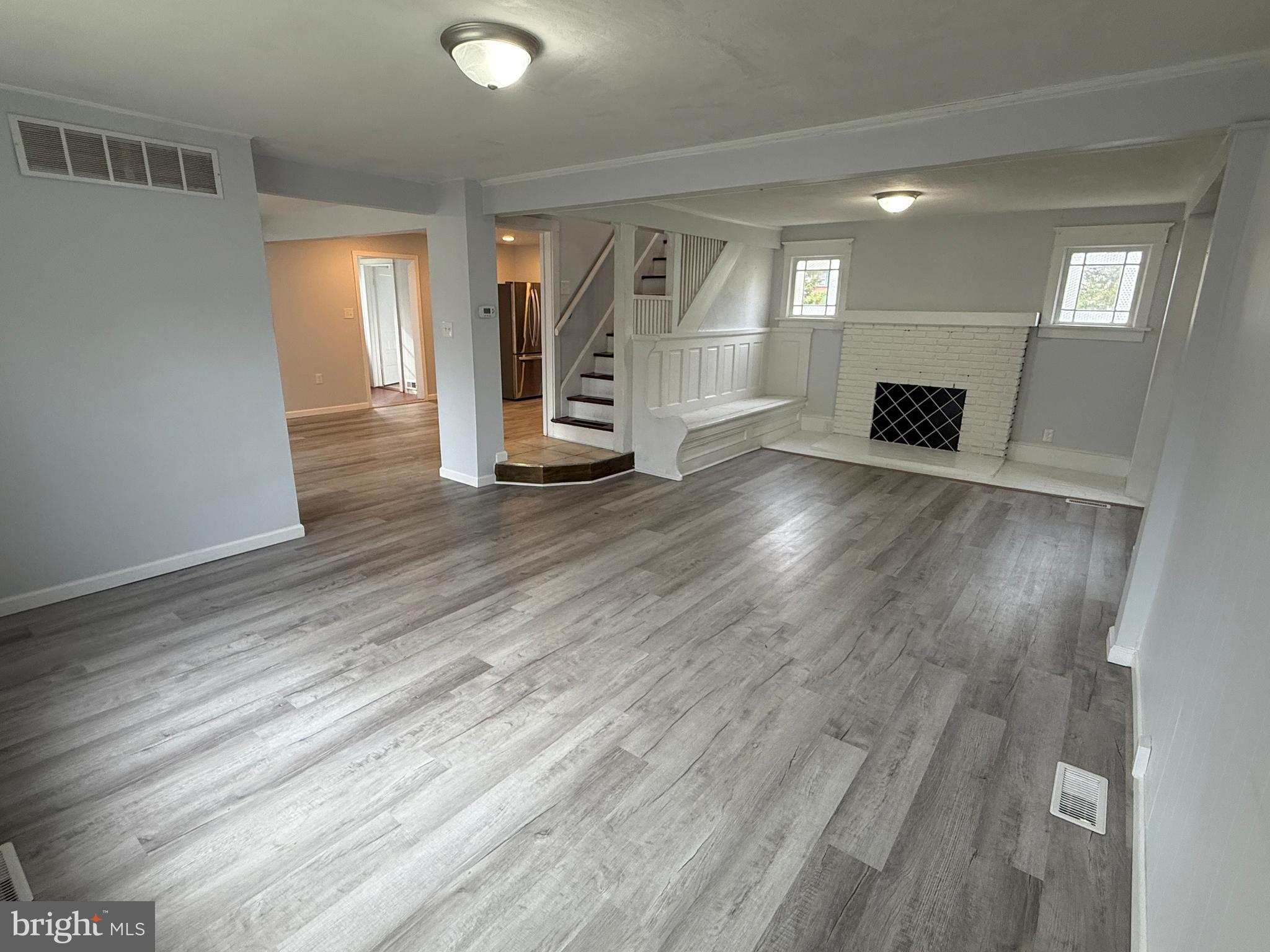 1036 South Spring Road Vineland, NJ 08361 - Photo 6 of 31 an empty room with wooden floor and fireplace