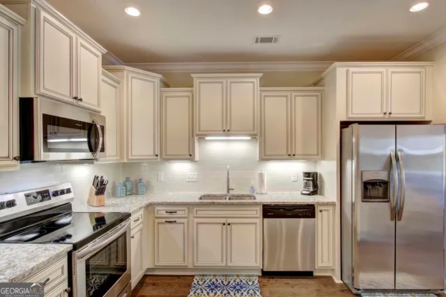 a kitchen with stainless steel appliances granite countertop a stove a refrigerator and a cabinets