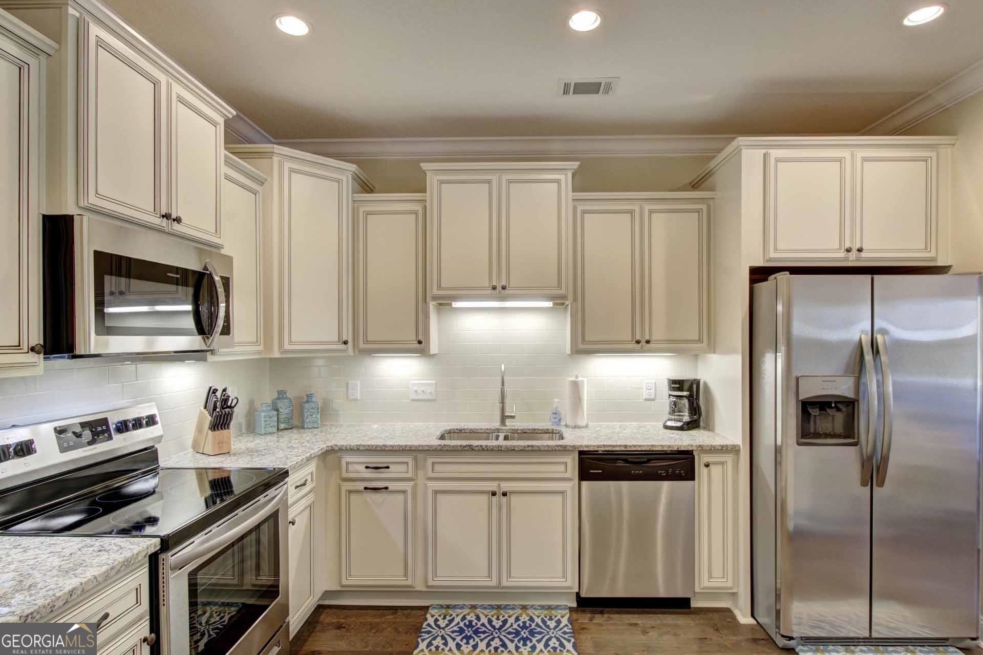 205 Mariners Circle St. Simons, GA 31522 - Photo 12 of 51 a kitchen with stainless steel appliances granite countertop a stove a refrigerator and a cabinets