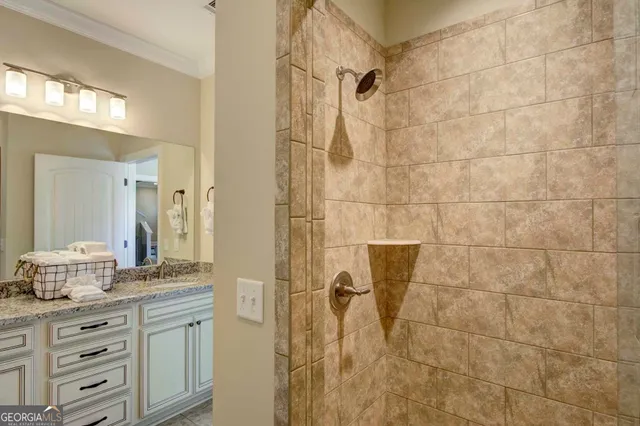 a bathroom with a granite countertop shower sink vanity and mirror