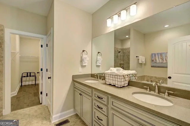a bathroom with a granite countertop double vanity sink mirror and