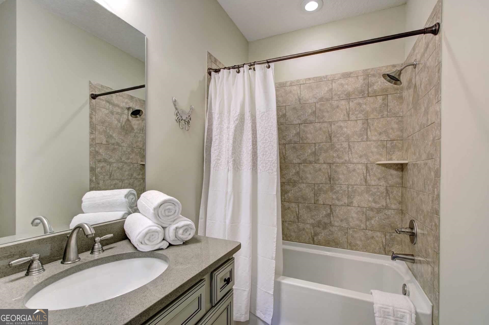 205 Mariners Circle St. Simons, GA 31522 - Photo 33 of 51 a bathroom with a granite countertop sink a mirror a bathtub and shower