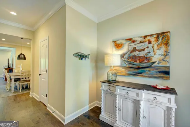 a view of a hallway to room with furniture and wooden floor