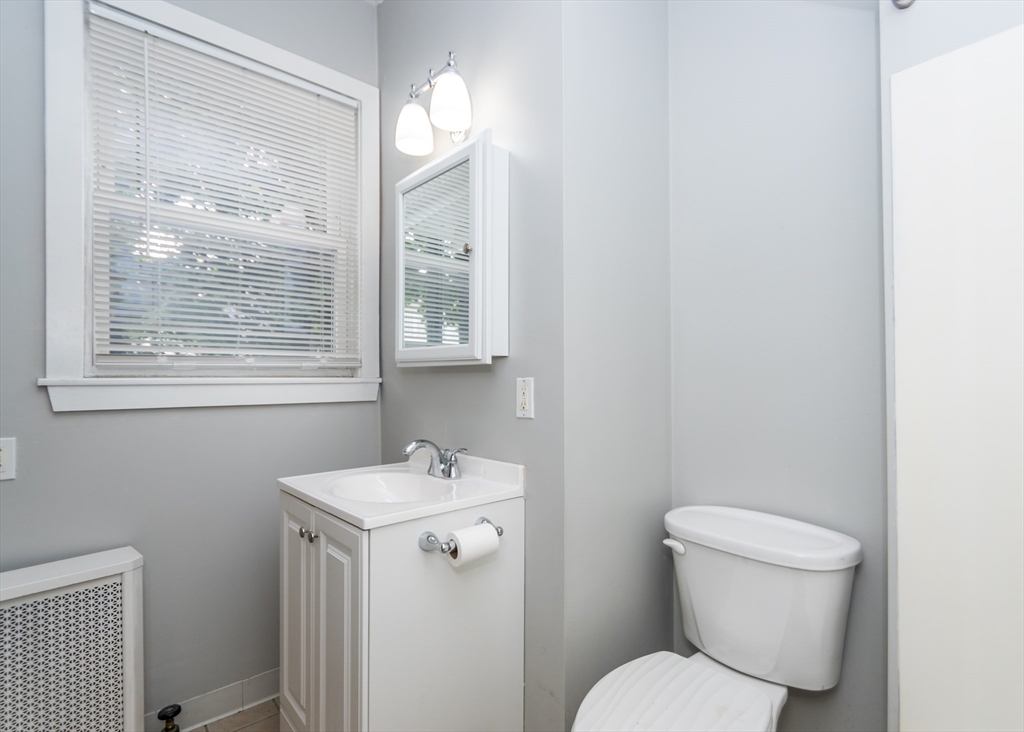 21 Gardner Street, Unit 1 Waltham, MA 02453 - Photo 17 of 19 a bathroom with a toilet sink and mirror