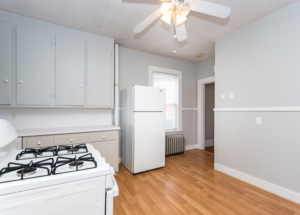 21 Gardner Street, Unit 1 Waltham, MA 02453 - Photo 3 of 19 a kitchen with a refrigerator and a stove top oven