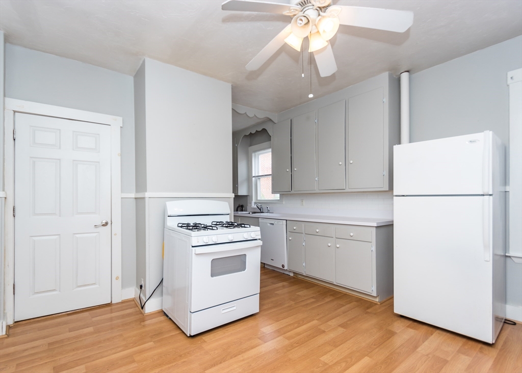 21 Gardner Street, Unit 1 Waltham, MA 02453 - Photo 4 of 19 a kitchen with a stove a refrigerator and a sink