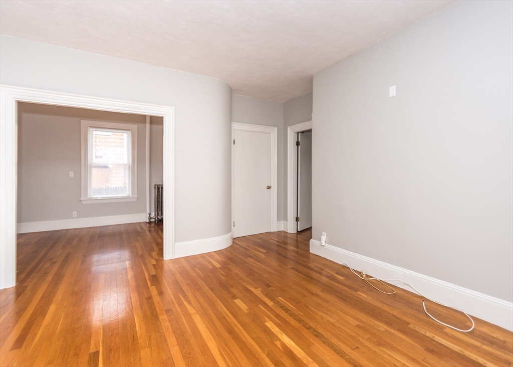 21 Gardner Street, Unit 1 Waltham, MA 02453 - Photo 10 of 19 a view of an empty room with wooden floor and a window