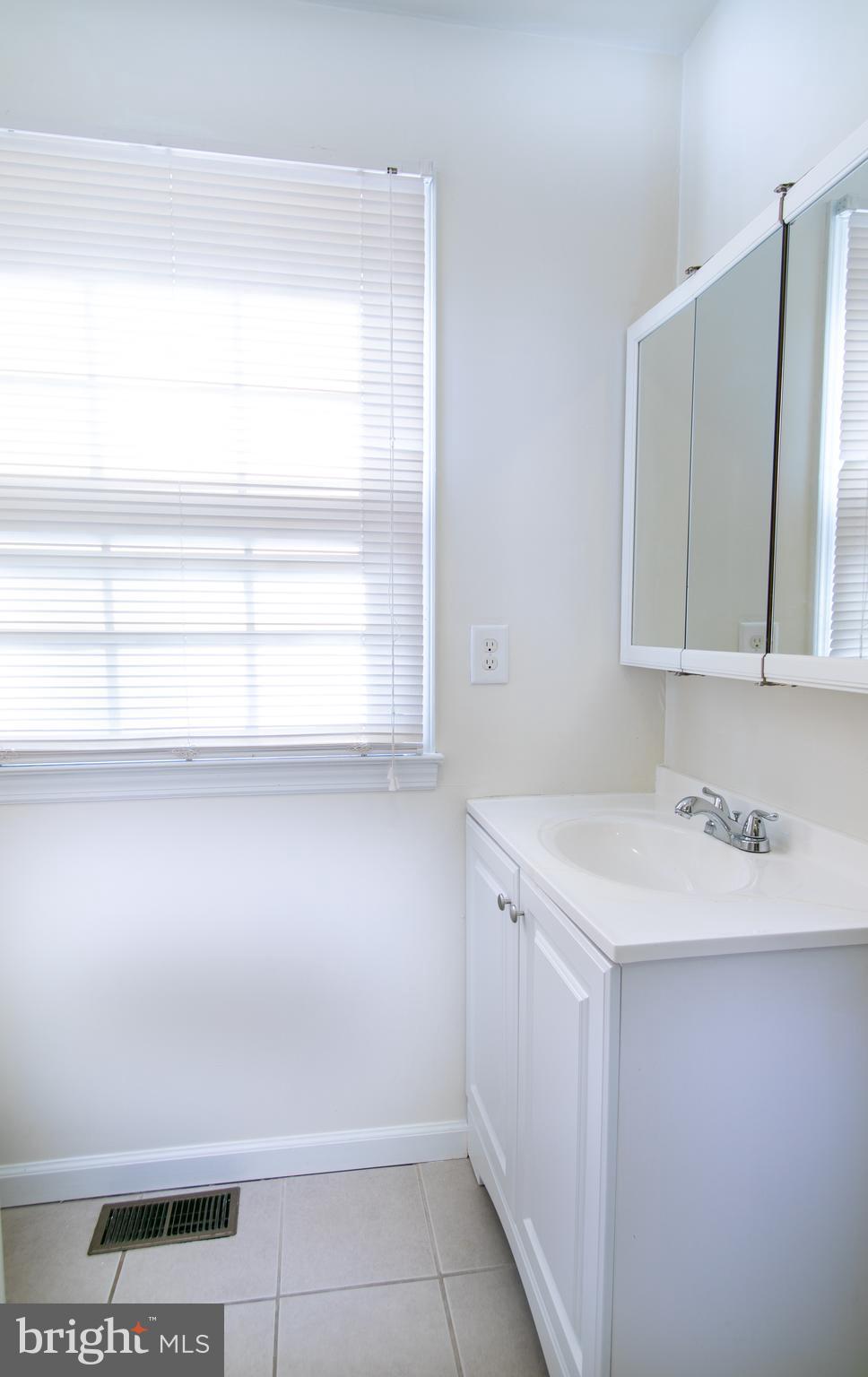 613 New York Road Glassboro, NJ 08028 - Photo 21 of 27 a bathroom with a sink a toilet and a mirror