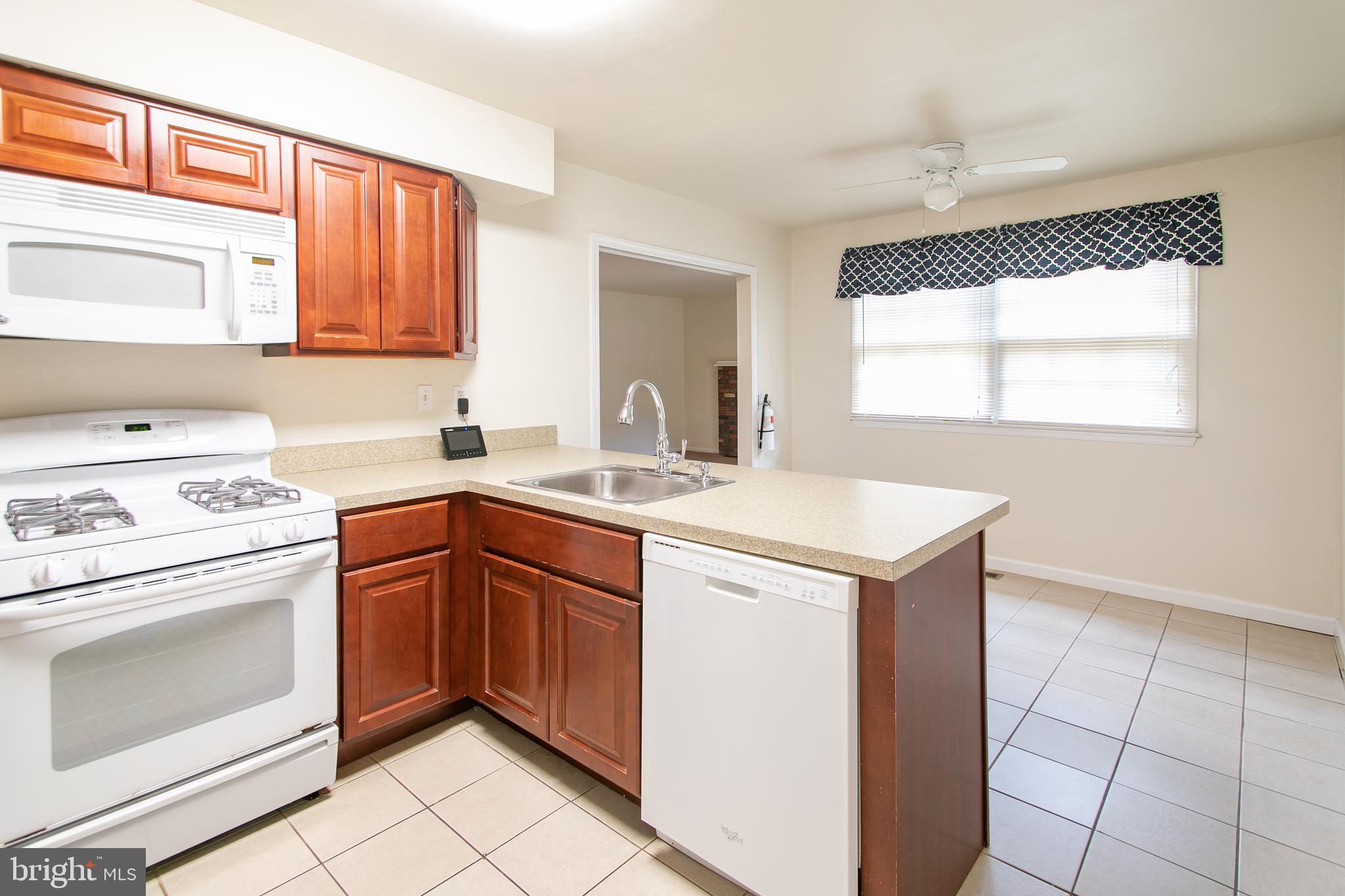 613 New York Road Glassboro, NJ 08028 - Photo 7 of 27 a kitchen with a sink cabinets appliances and a window