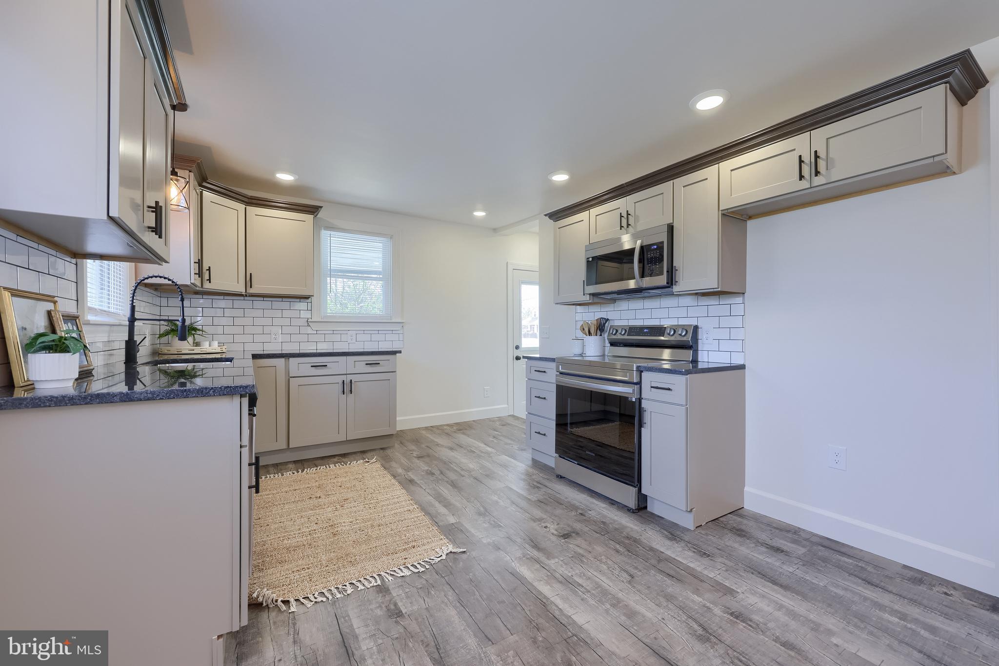 1151 Delta Road Red Lion, PA 17356 - Photo 15 of 44 a kitchen with granite countertop a stove top oven a sink dishwasher and a microwave oven on the wooden floor