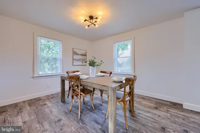 a view of a dining room with furniture a chandelier and wooden floor