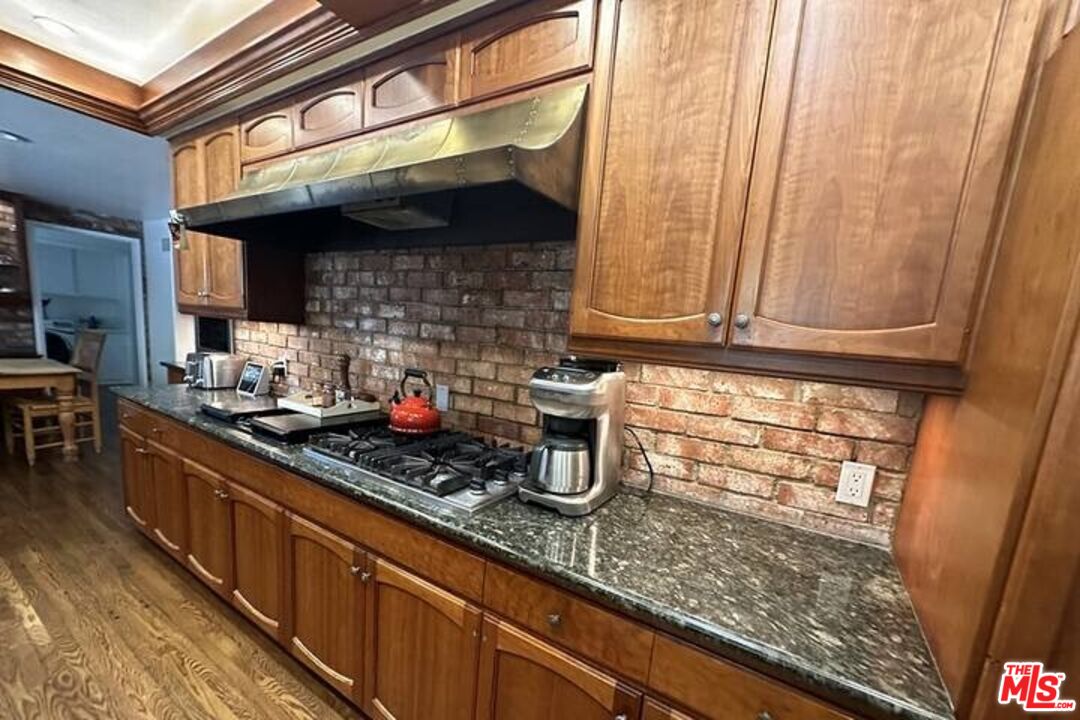 1456 Roscomare Road Los Angeles, CA 90077 - Photo 11 of 21 a kitchen with stainless steel appliances granite countertop a sink a stove and cabinets