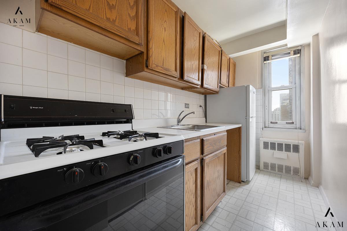 310 East 70th Street, Unit 10L Manhattan, NY 10021 - Photo 1 of 13 a kitchen with stainless steel appliances a stove and a refrigerator