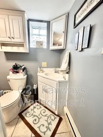a bathroom with a toilet a sink and a window