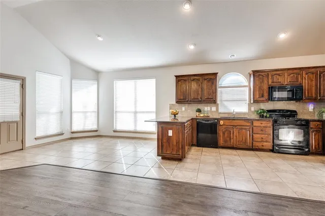 a kitchen with stainless steel appliances granite countertop a stove a sink and a microwave