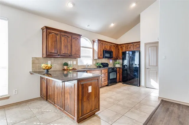 a kitchen with stainless steel appliances granite countertop a stove and a refrigerator