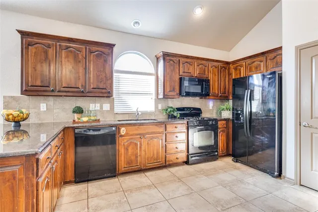 a kitchen with stainless steel appliances granite countertop a refrigerator stove and sink