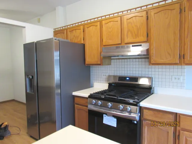 a kitchen with stainless steel appliances granite countertop a refrigerator a stove and a microwave