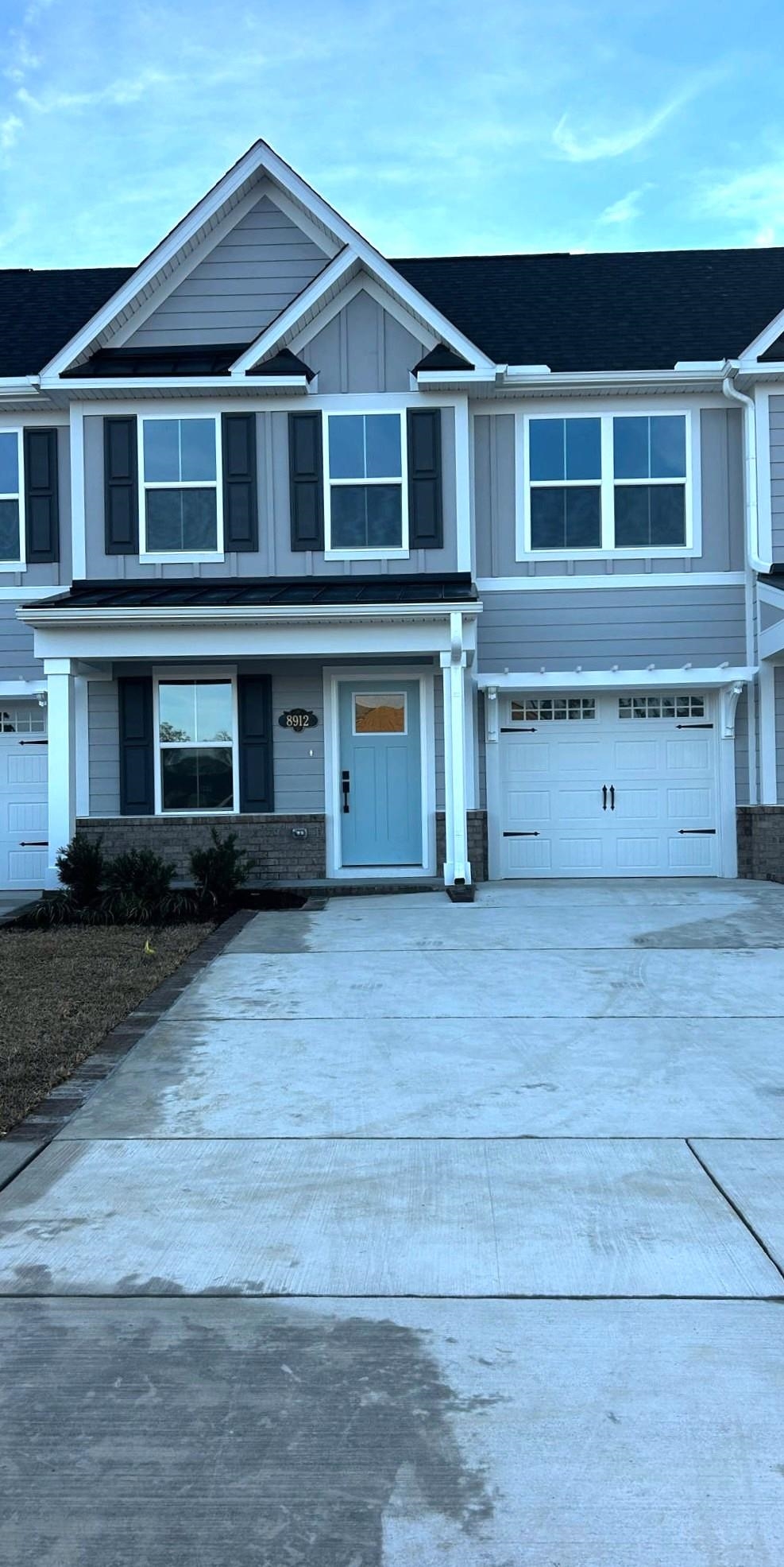 8912 Brynlee Road, Unit 6D Longs, SC 29568 - Photo 1 of 1 View of front of home with driveway, an attached garage, brick siding, and board and batten siding