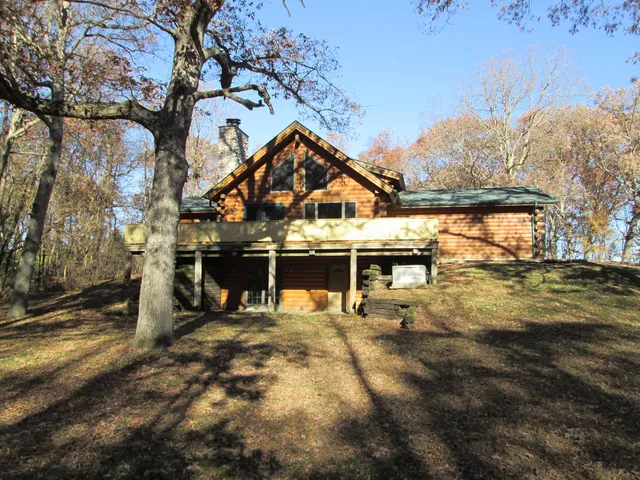 a view of a large house with a large trees next to a yard