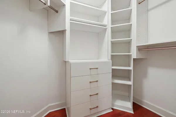 a view of walk in closet with empty racks