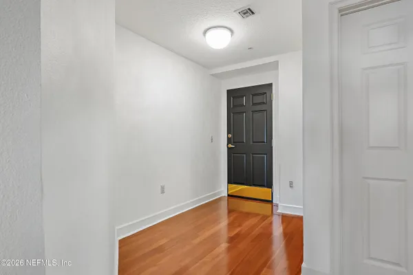 a view of an empty room with wooden floor