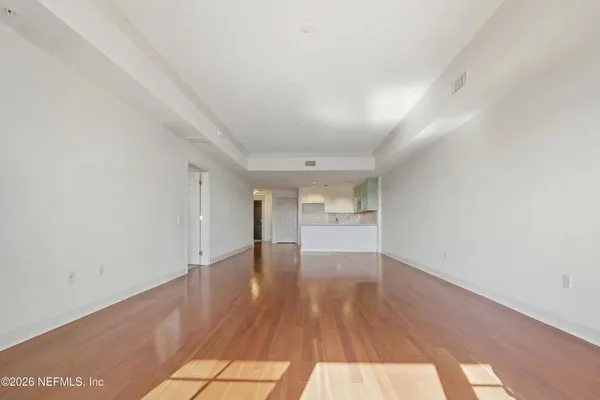 a view of empty room with wooden floor