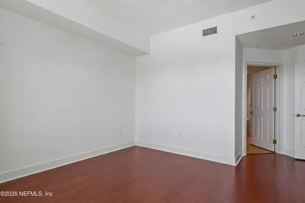 an empty room with wooden floor and closet