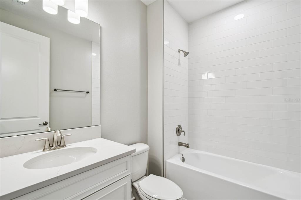 17019 Overstory Road Orlando, FL 32820 - Photo 22 of 85 a bathroom with a granite countertop toilet sink and a bathtub