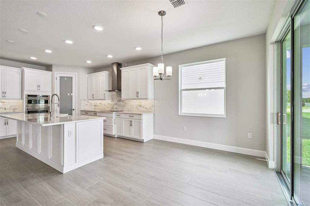 17019 Overstory Road Orlando, FL 32820 - Photo 4 of 85 a kitchen with white cabinets and window