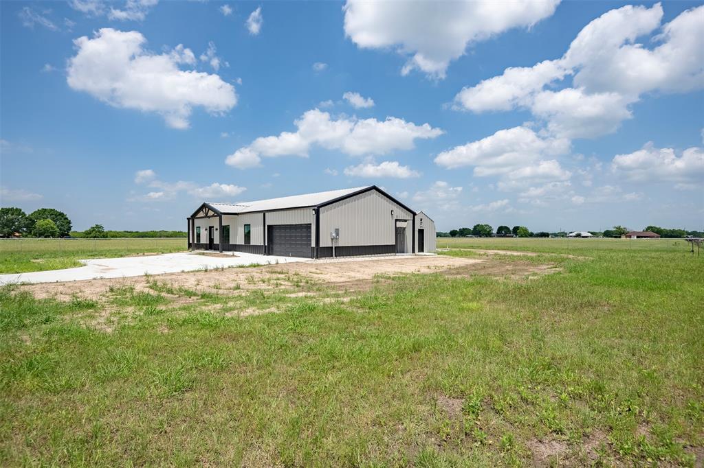 419 Brazier Road Ennis, TX 75119 - Photo 1 of 1 View of front facade featuring an outdoor structure, a rural view, a front yard, and a garage