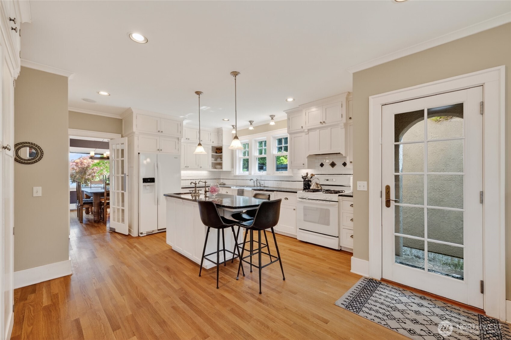 258 North Forest Street Bellingham, WA 98225 - Photo 19 of 40 a kitchen with kitchen island a dining table chairs stainless steel appliances and cabinets